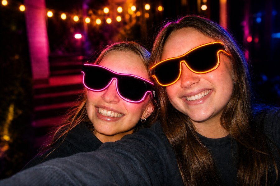 Customer wearing pink Sunglasses At Night glasses at an outdoor party