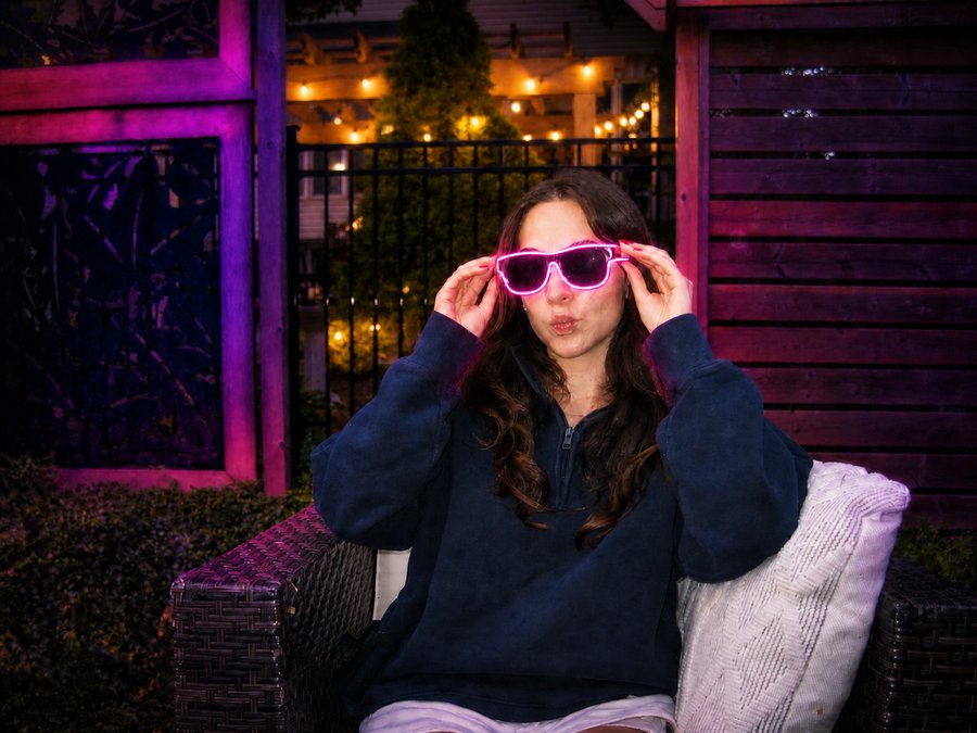 Two friends wearing pink and orange Sunglasses At Night glasses